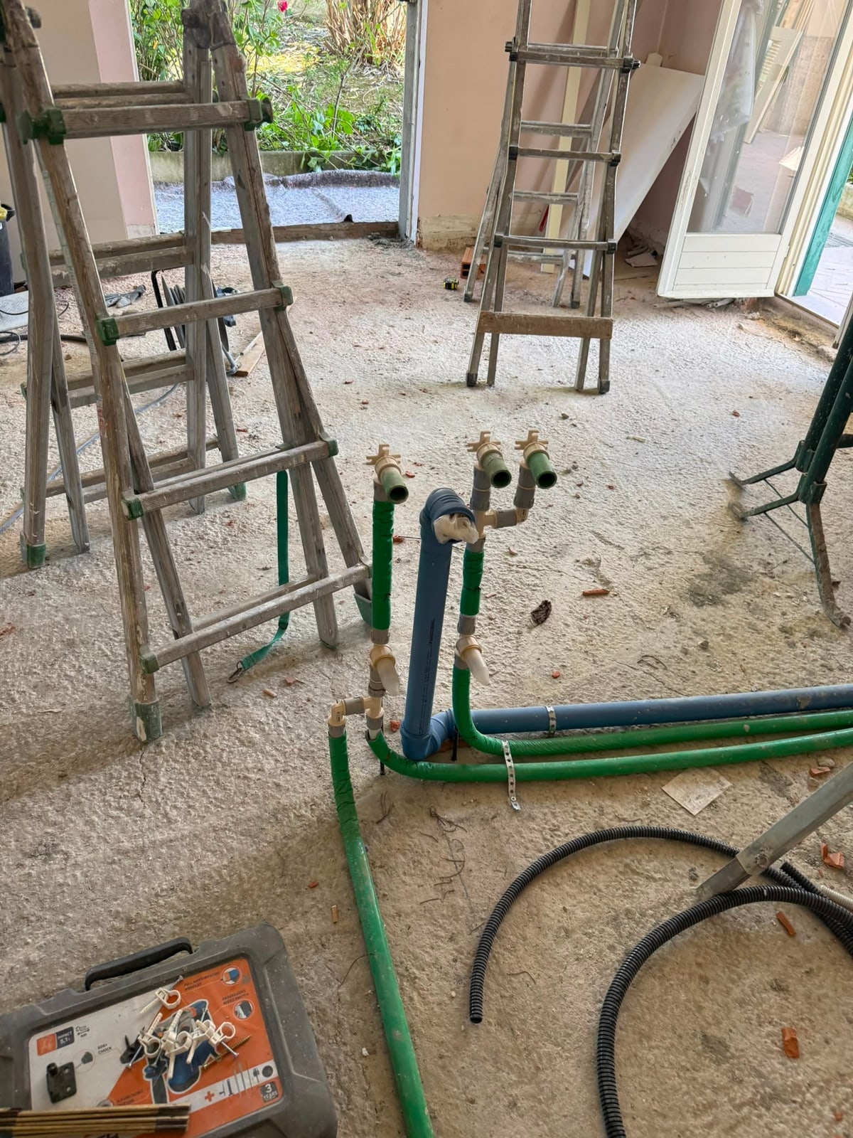 Distribuzione di tubazioni verdi e blu sul pavimento di un cantiere